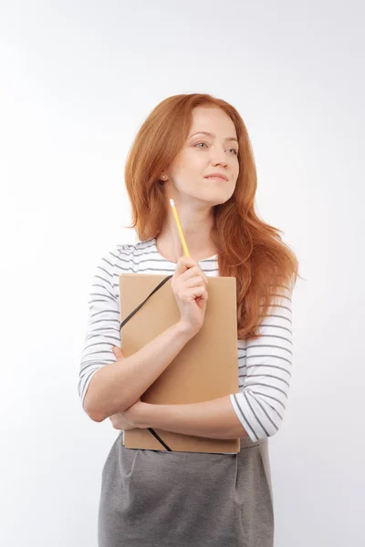 Mujer pelirroja sosteniendo carpeta y lápiz —  Fotos de Stock