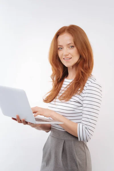 Affascinante donna dai capelli rossi in posa con computer portatile — Foto Stock