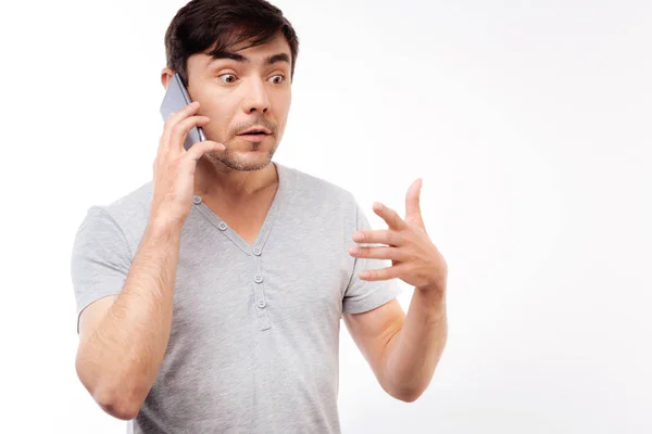Удивленный мужчина, слушающий шокирующие новости по телефону — стоковое фото