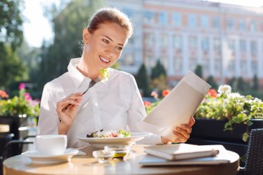 Güzel kadın dışarı yemek yerken belgeleri okuma