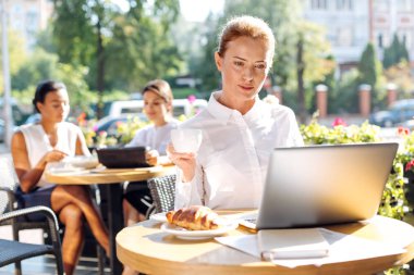Güzel kadın kahve yudumlarken e-postaları okuma
