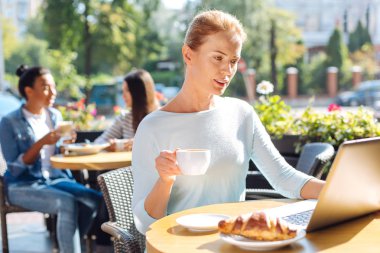 Bir fincan kahve okuma sırasında tutan hoş kadın