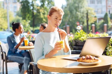 Güler yüzlü içme ve tarassut video üstünde laptop genç kadın