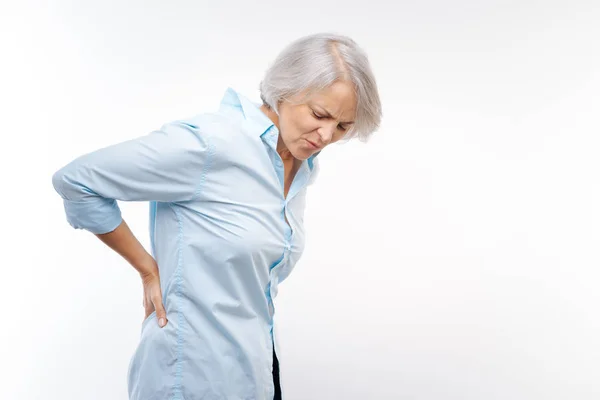 Grauhaarige Frau leidet unter Schmerzen im unteren Rücken — Stockfoto