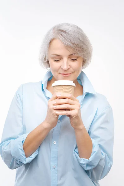 Grey-haired woman enjoying aroma of coffee — Stock Photo, Image