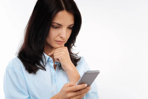 Serious woman reading newsfeed on phone — Stock Photo, Image