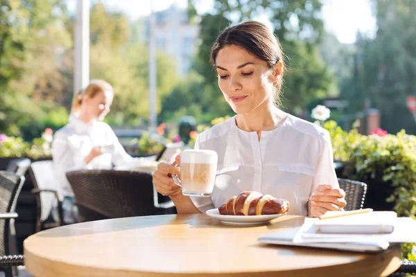 Mujer bastante joven bebiendo café con leche en la cafetería — Foto de Stock