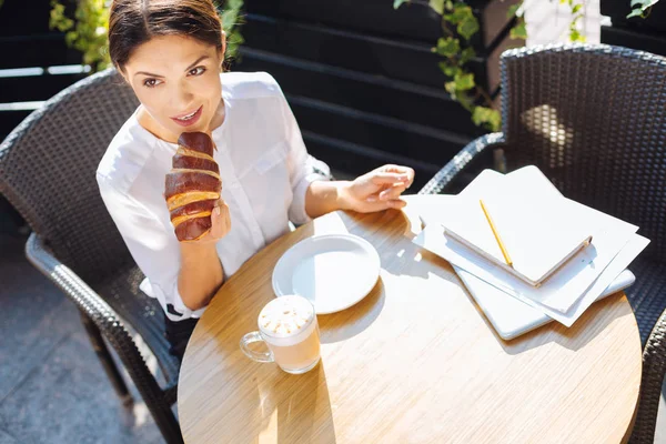 Vista superior de la hermosa mujer comiendo croissant en la cafetería —  Fotos de Stock