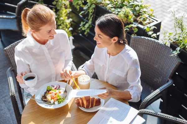 Vackra kolleger talar om arbete vid lunch — Stockfoto