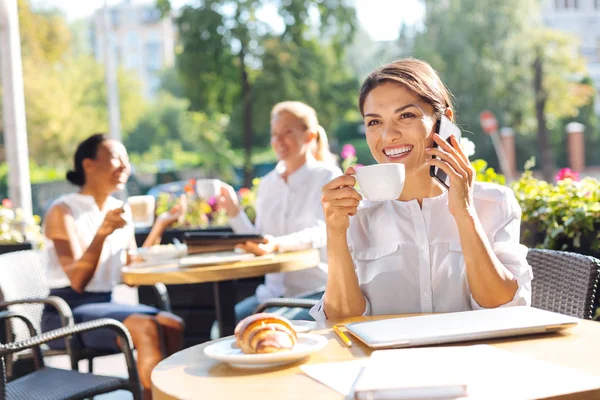 Optimistická žena smíchy když mluví o telefonu v kavárně — Stock fotografie