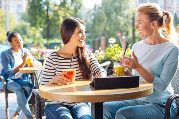 Two friends talking and drinking smoothie in cafe — Stock Photo, Image