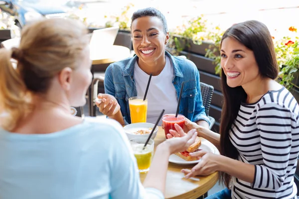 Mulheres otimistas fofocando durante o almoço no café — Fotografia de Stock