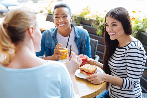 Tři pozitivní ženy vyprávět vtipy během oběda — Stock fotografie