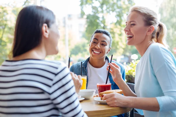 Female friends remembering good old days at lunch — Stock Photo, Image