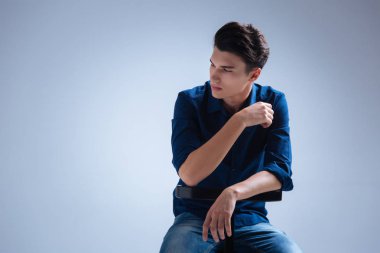 Yakışıklı adam siyah sandalyeye yaslanmış