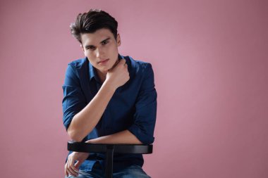 Seksi genç adam sandalyeye poz