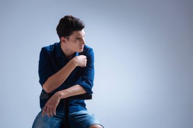 Kızgın esmer gri arka plan üzerinde oturan