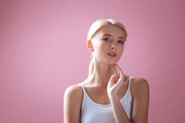 Kendine güvenen sarışın boynuna dokunuyor