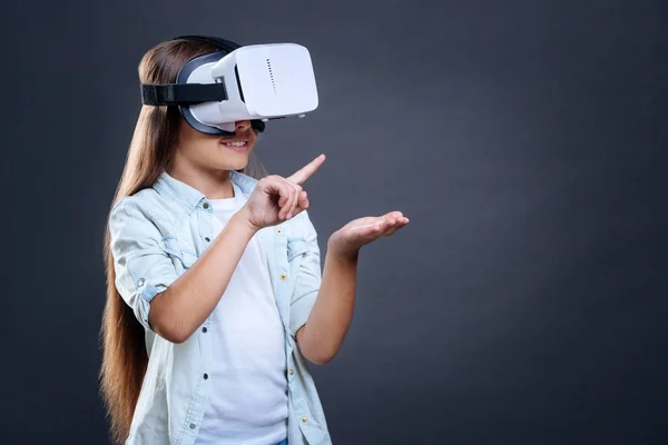 Menina alegre alegre segurando um dispositivo virtual — Fotografia de Stock