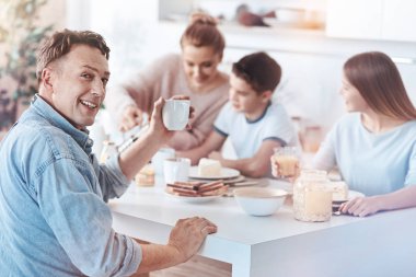 Aile ile yemek yerken kamera için poz dostu baba