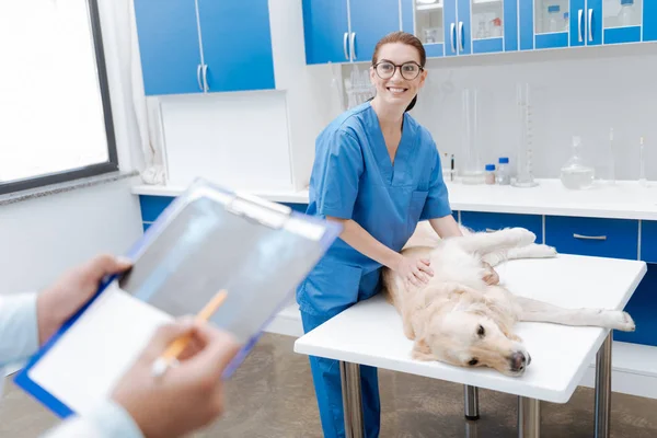 Vackra brunett i enhetlig Lyssna på hennes assistent — Stockfoto