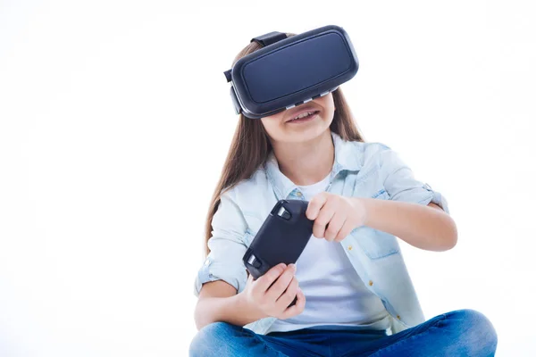 Menina bonito alegre segurando um console de jogo — Fotografia de Stock