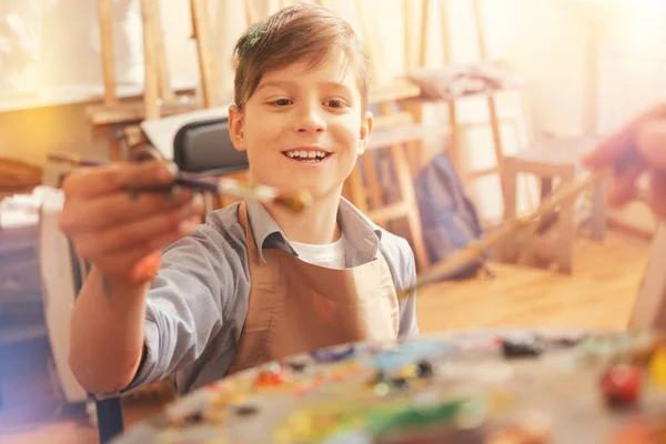 Radiante niño radiante mientras mezcla pinturas — Foto de Stock