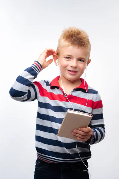 Schattige kleine jongen, luisteren naar muziek en het bedrijf laptop — Stockfoto