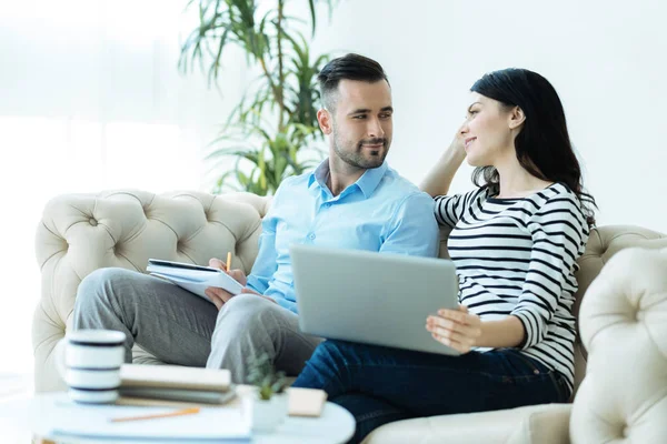 Adorable pareja milenaria mirándose mientras trabajan — Foto de Stock