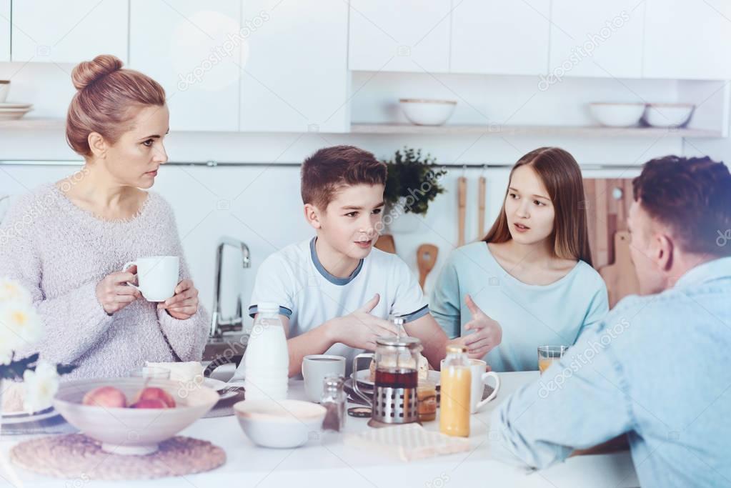 Four membered family chatting during breakfast