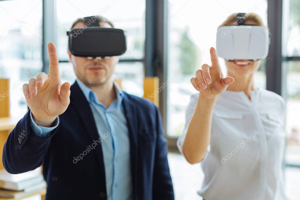Nice cheerful people standing in front of the virtual screen