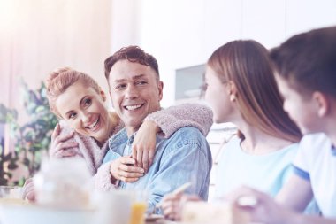 Mutlu aile birlikte kahvaltı yaparken sohbet