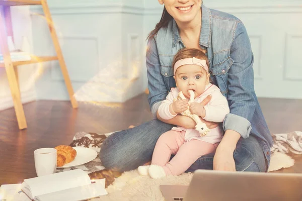 Smiling woman holding child on her leg — Stock Photo, Image