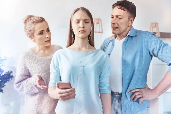 Teenage girl listening music refusing to listen her parents — Stock Photo, Image