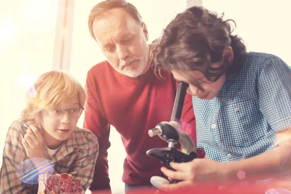 Attente jongen met krullend haar kijkend door het oculair — Stockfoto