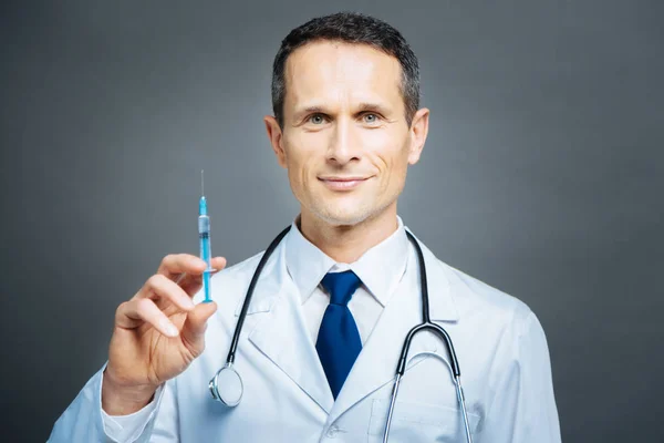 Cheerful practitioner holding syringe and smiling — Stock Photo, Image