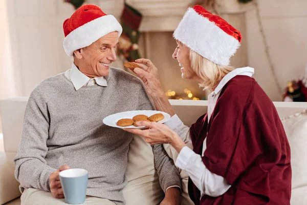 Playful elderly woman feeding her man — Stock Photo, Image