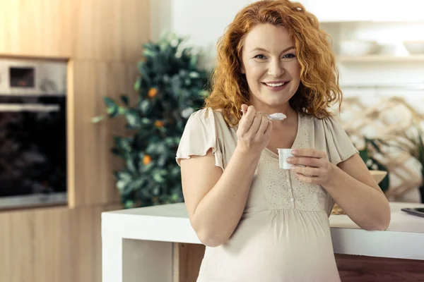 Adorable pregnant woman eating yoghurt — Stock Photo, Image