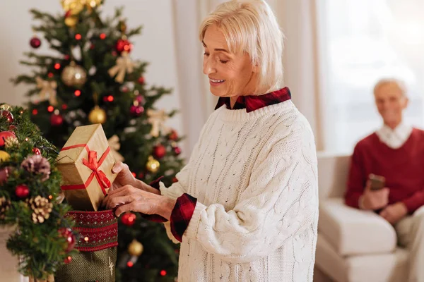 Persona femenina atenta ocultando caja de regalo — Foto de Stock