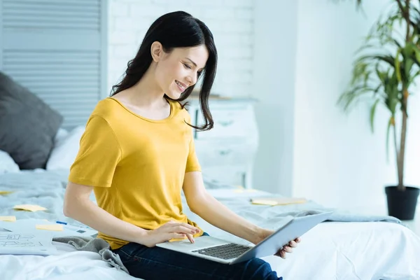 Senhora encantadora sorrindo enquanto trabalhava no laptop — Fotografia de Stock