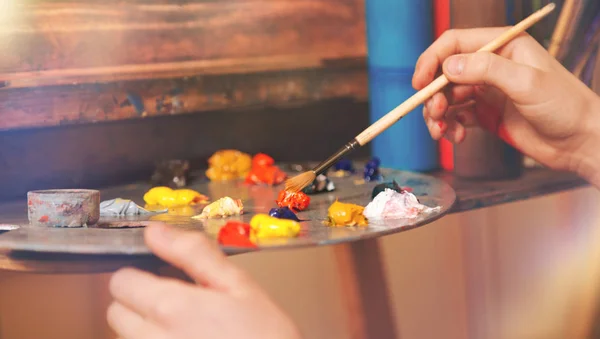 Close up look on hand of child mixing oil paints — Stock Photo, Image