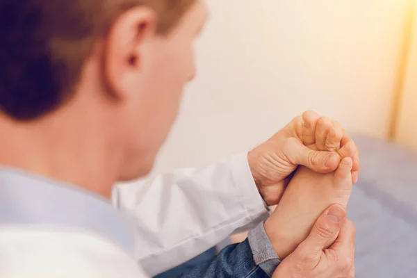 Close up of little foot that being in male hands — Stock Photo, Image