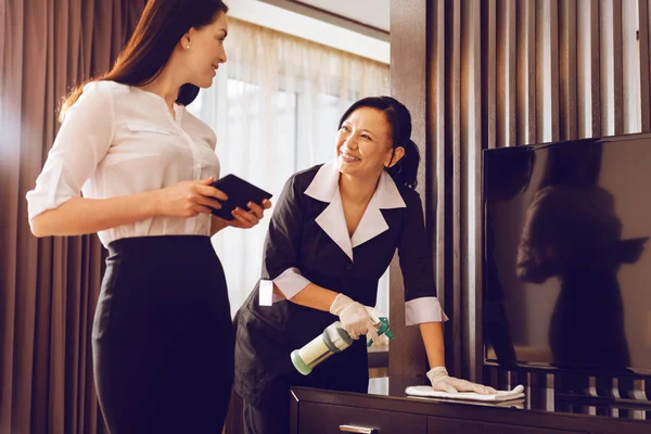 Positive delighted chambermaid polishing furniture — Stock Photo, Image