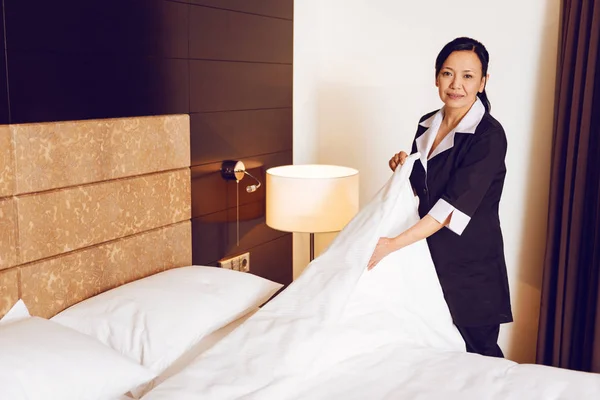 Positiv chambermaid att sätta täcke över kuddar — Stockfoto