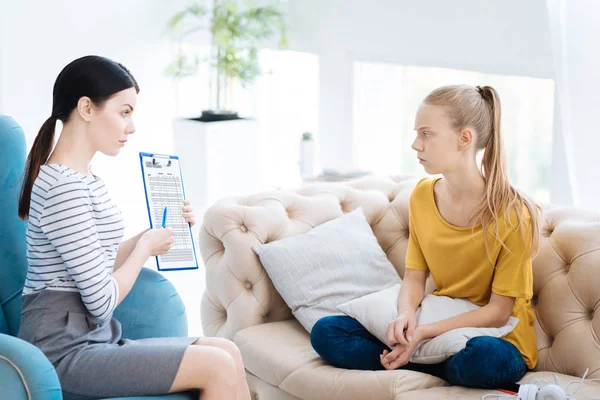 Smart experienced psychologist showing notes to her patient — Stock Photo, Image