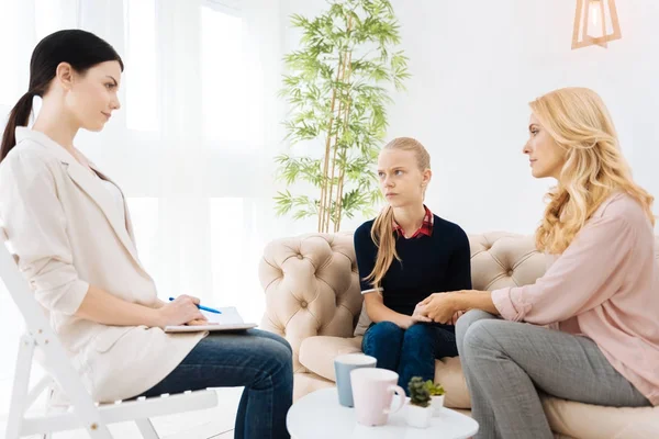 Serious experienced psychologist listening to her patients — Stock Photo, Image