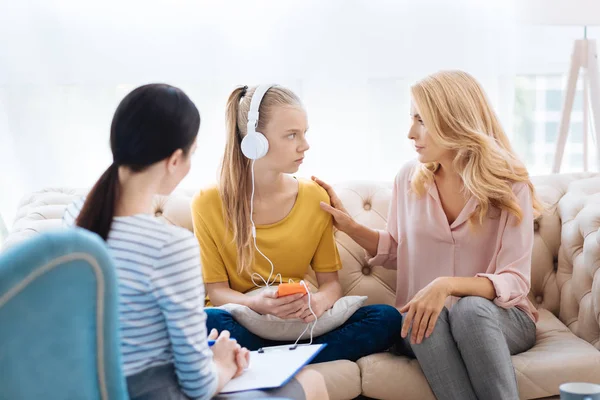 Mujer rubia agradable sosteniendo a sus hijas hombro — Foto de Stock