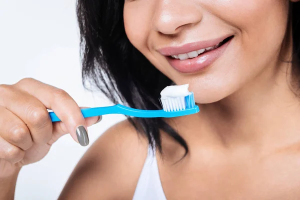 Крупним планом молода жінка тримає зубну щітку — стокове фото