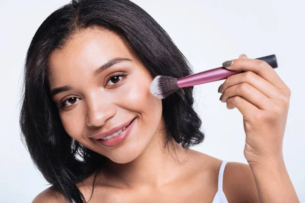 Joven alegre usando pincel de polvo — Foto de Stock