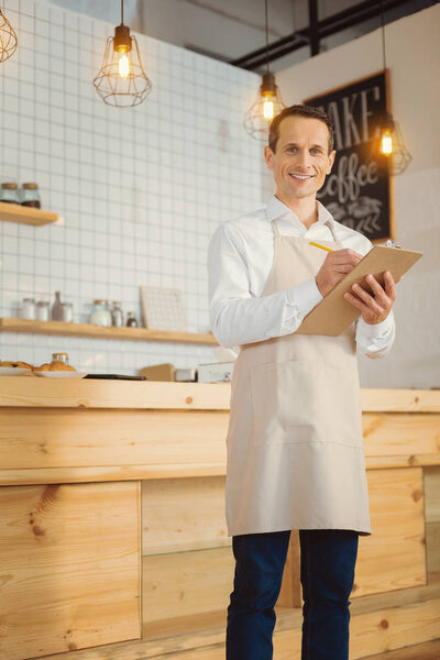 Joyful smart man taking notes